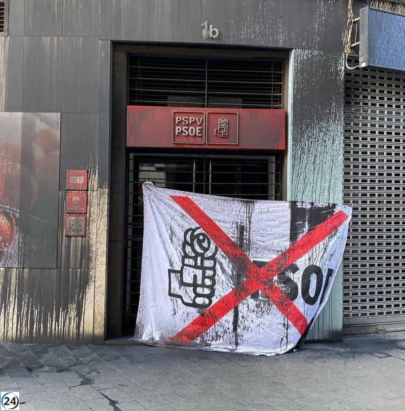 Atacan la sede del PSPV-PSOE en València con graffiti y una pancarta que desdibuja su logo.