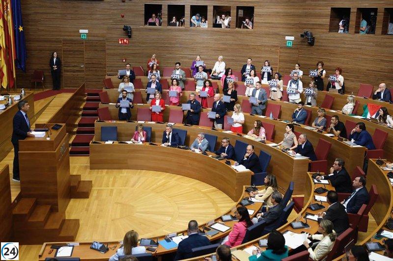 Mazón rinde homenaje a las 229 víctimas de la dana mientras la oposición muestra carteles en el pleno.